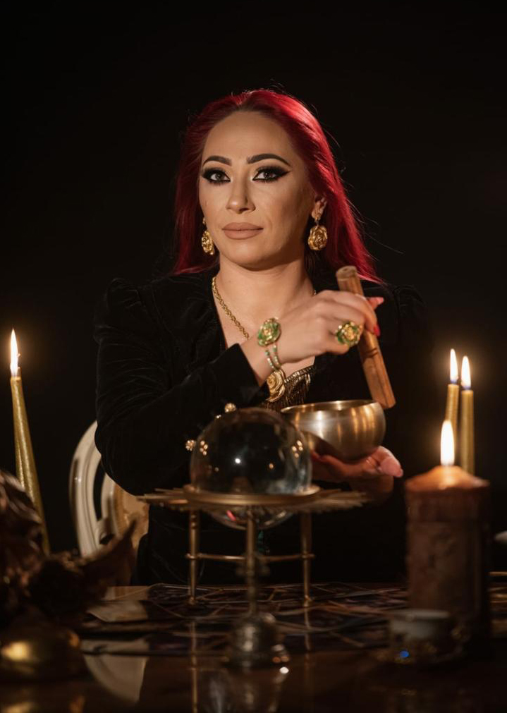 Powerful Witch Danusia with the crystal ball and the singing bowl, among candles